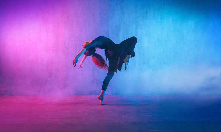 Woman dancing in neon light studio