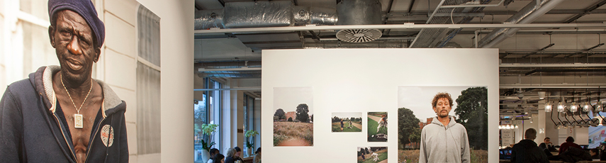 Inside of an art gallery with different size pictures on the walls.