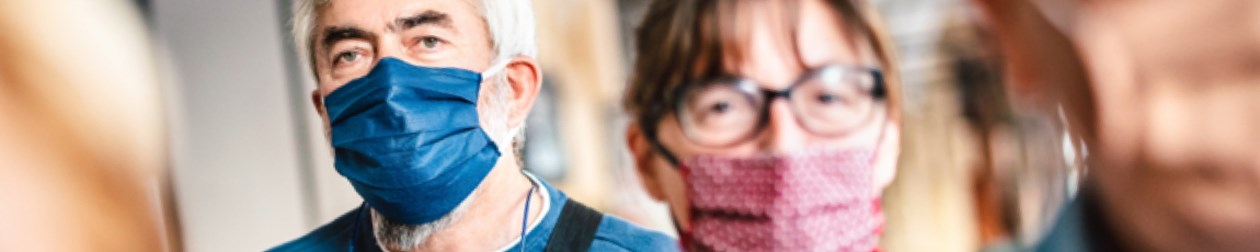 Man and lady wearing surgical face masks.