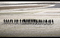 a line of dancers on a beach