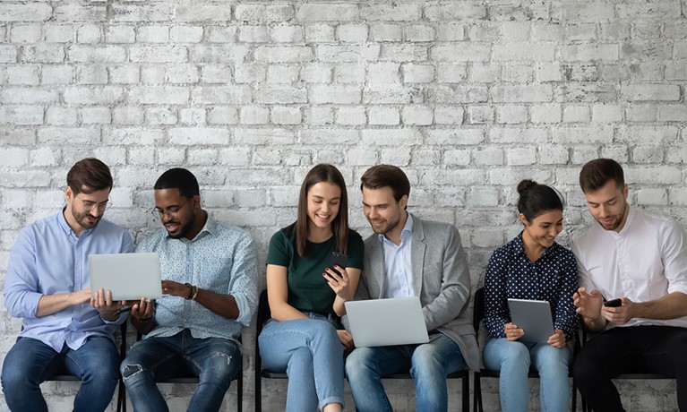 Diverse group of people sat in pairs on laptops