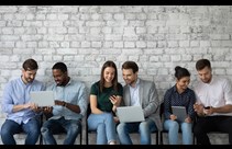 Diverse group of people sat in pairs on laptops