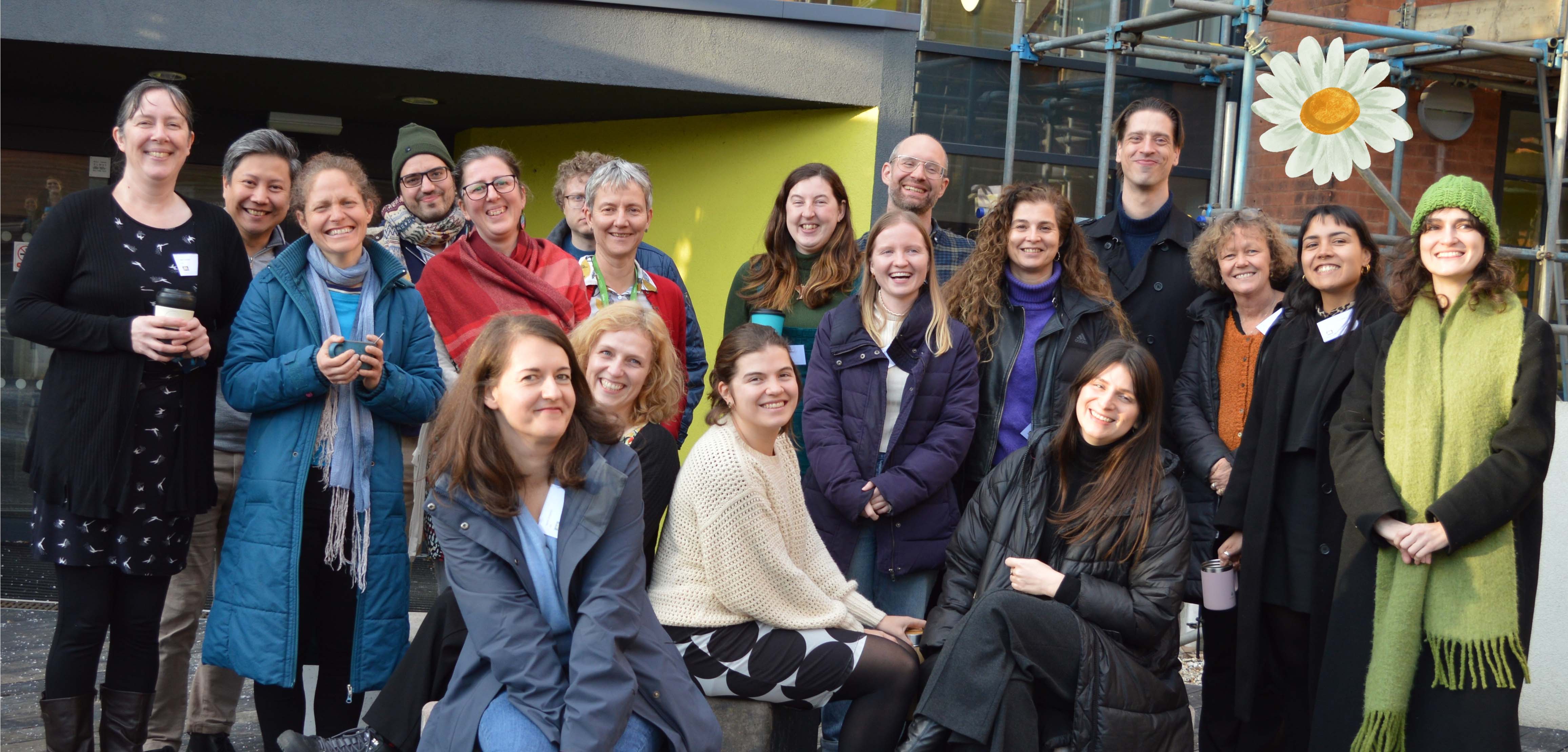DAISY project team pose outside a building with a big daisy