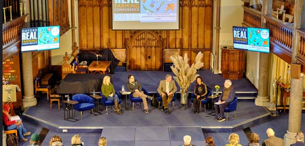 5 people on the stage at the oxford real farming event from up high