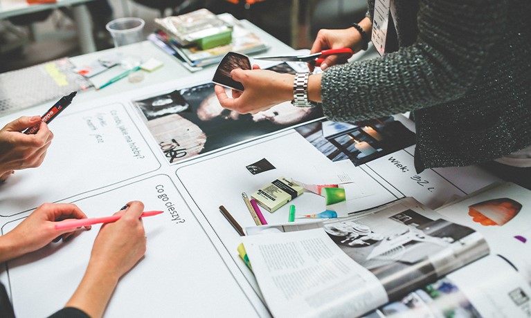 Three people brainstorming with paper and pens