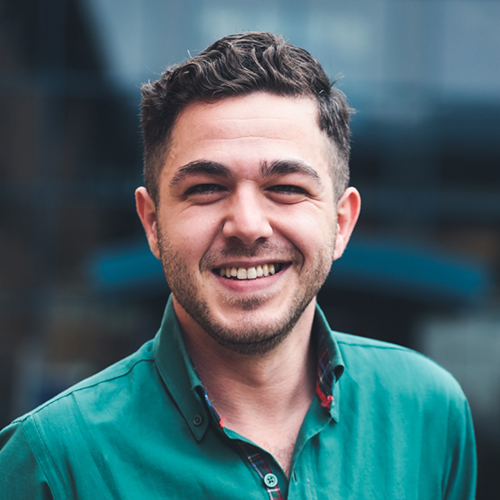Duru Imrie-Kuzu a smilling man in a green collared shirt