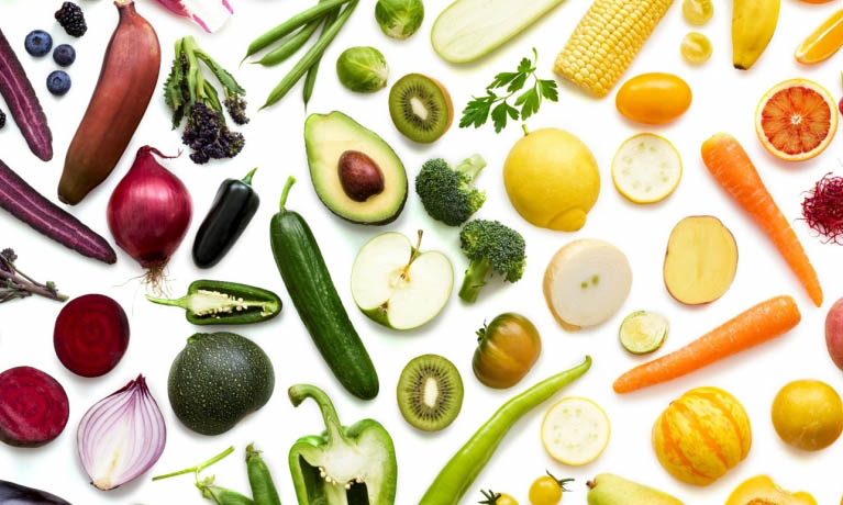 A variety of fresh fruit and vegetables organised by colour