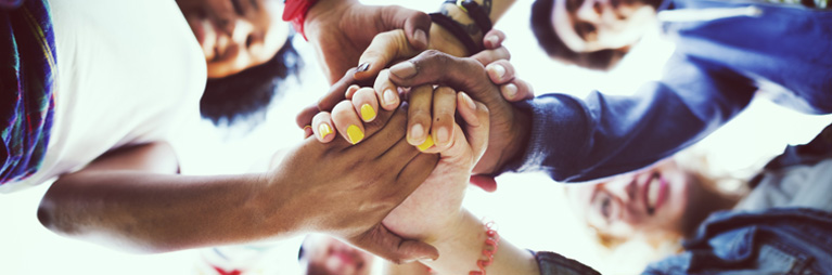 A diverse group of people holding hands.