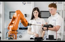 white female and male students working with cobot