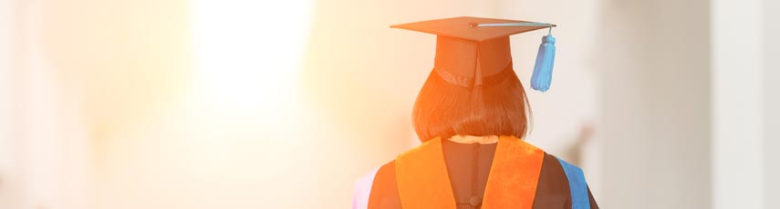 Student in cap and gown walking down corridor