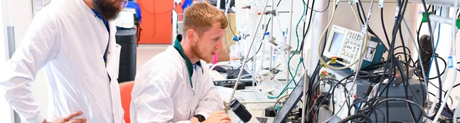 two men working in laboratory in white cloaks 