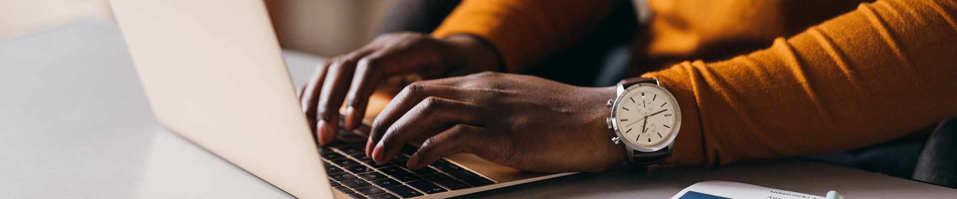 close up of a person typing on a laptop