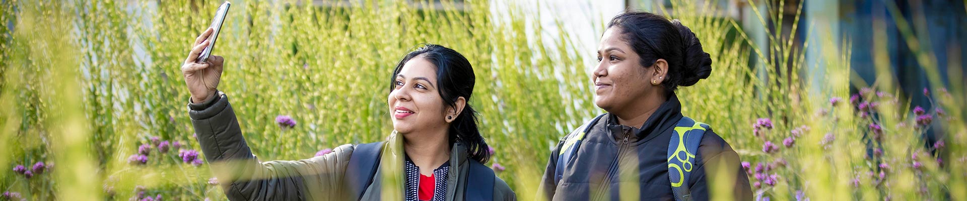 Two students outside in the garden taking a selfie