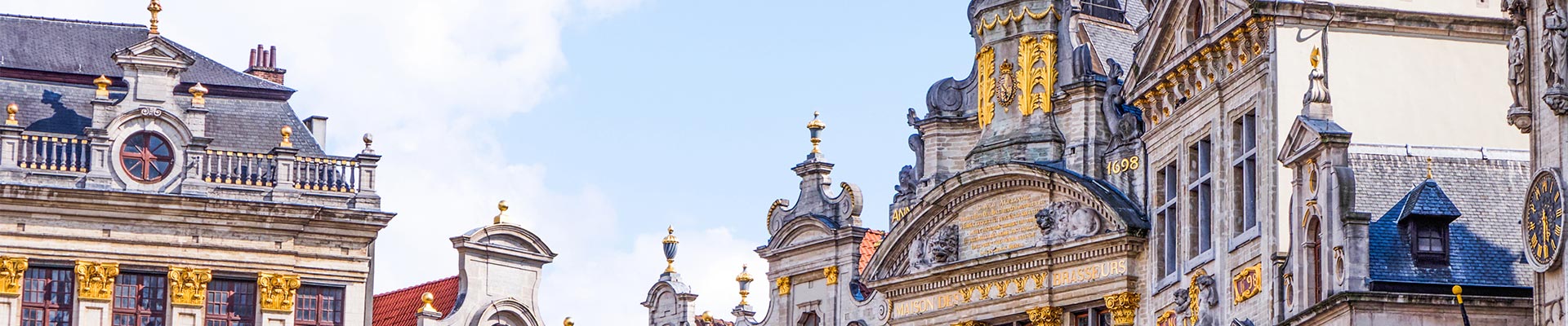 The old city centre buildings in Brussels against a blue sky.