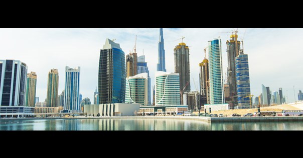 View of city skyscrapers by a waterway in Dubai.