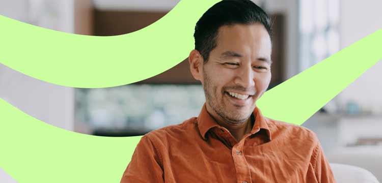 Smiling older asian man looking at a laptop with a green swirl in the background