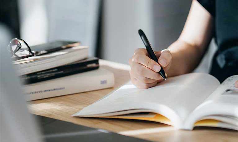 Close up of a person writing in a journal