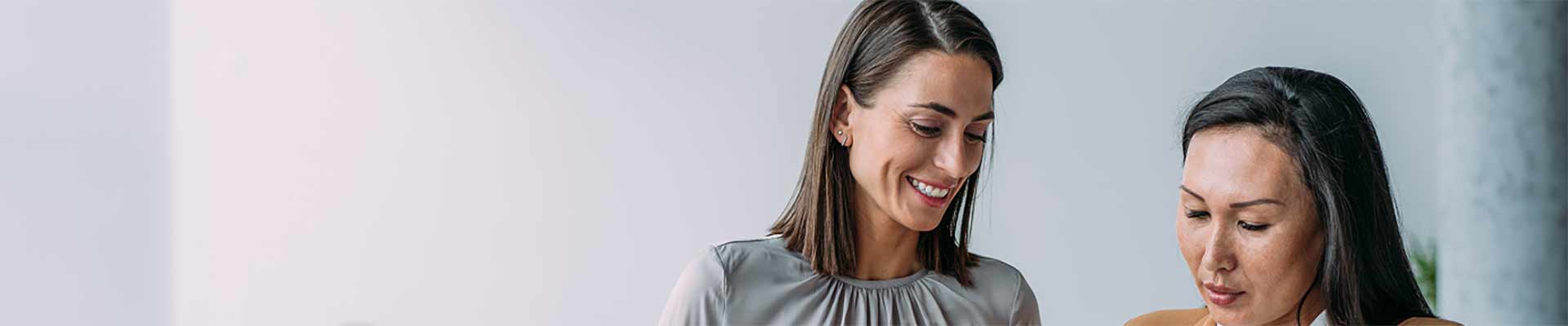 three men wearing yellow vests and hard hats looking over construction plans