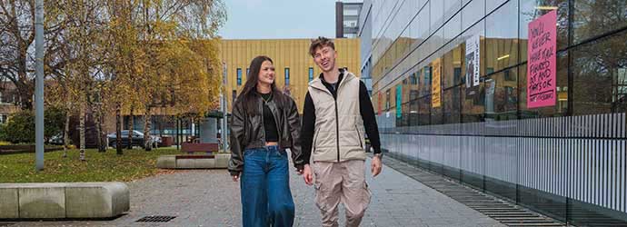 two students walking outside the Hub building