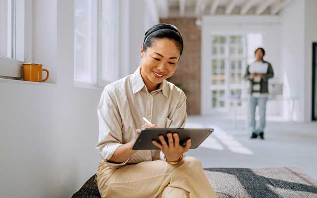 Older Asian lady holding a tablet 