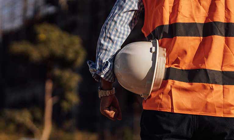 man wearing hi vis holding hard hat under his arm