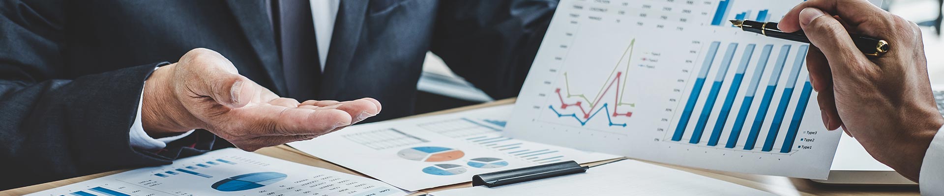 People looking through some finance data on sheets of paper