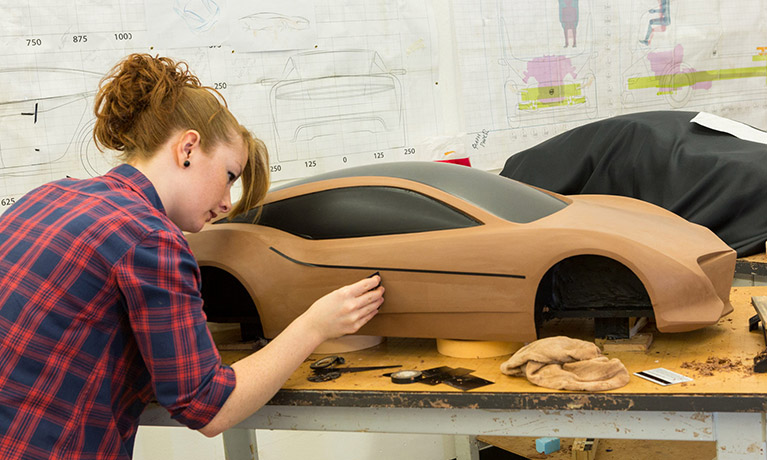 Automotive and transport student painting a car model