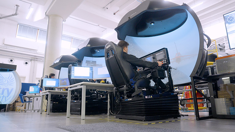 Male student working on a flight simulator 