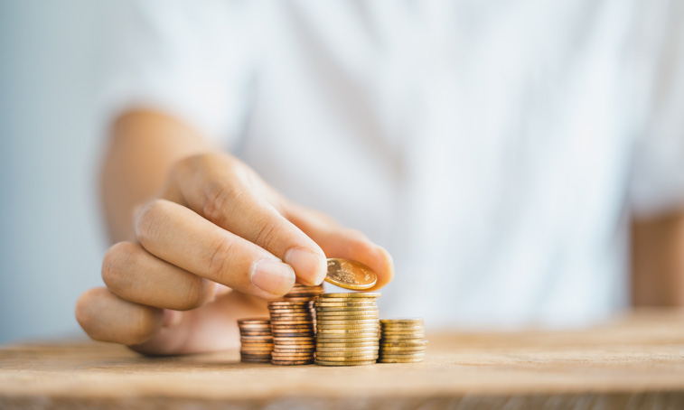 close up of hand stacking coins