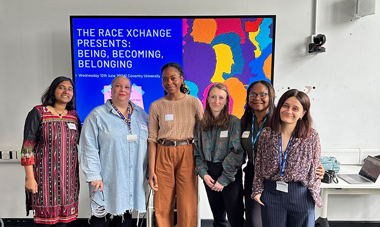 Staff standing infront of a presentation screen