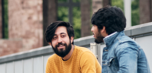 International students sat chatting in The Hub's rooftop garden with the cathedral ruins behind them.