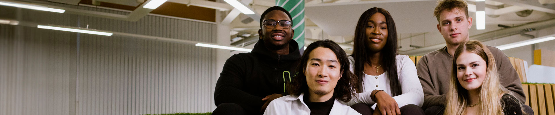 A group of students sat together smiling at the camera.