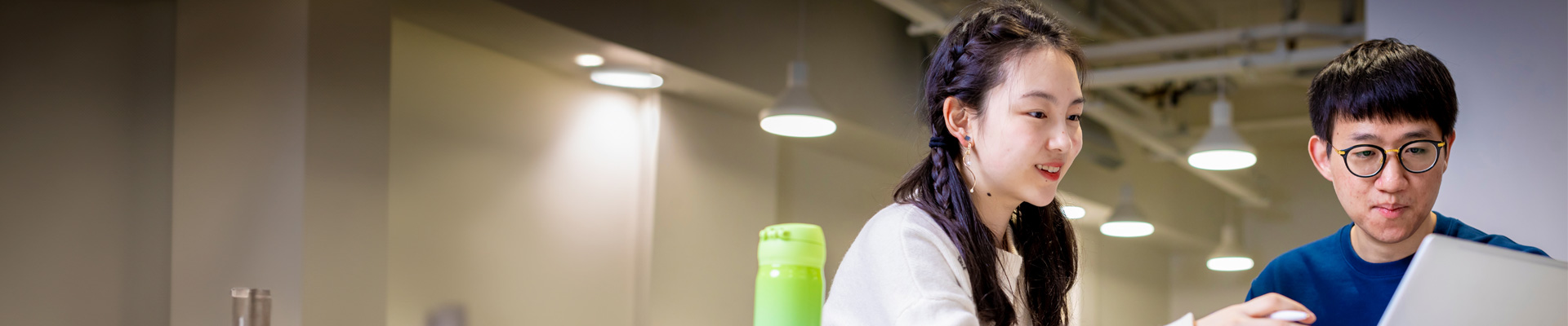 Two international students looking at a laptop