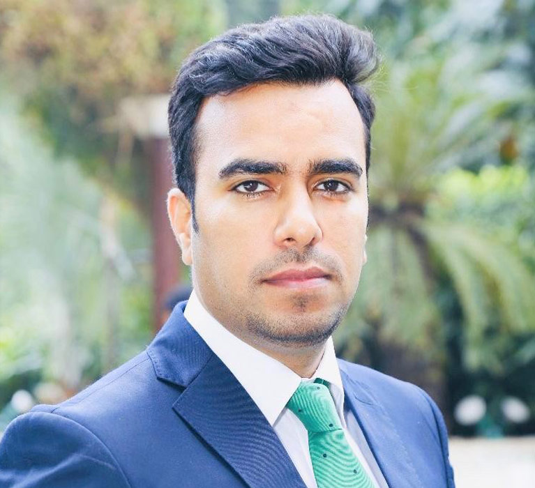 Portrait of Tarang Chowdhary with greenery in the background