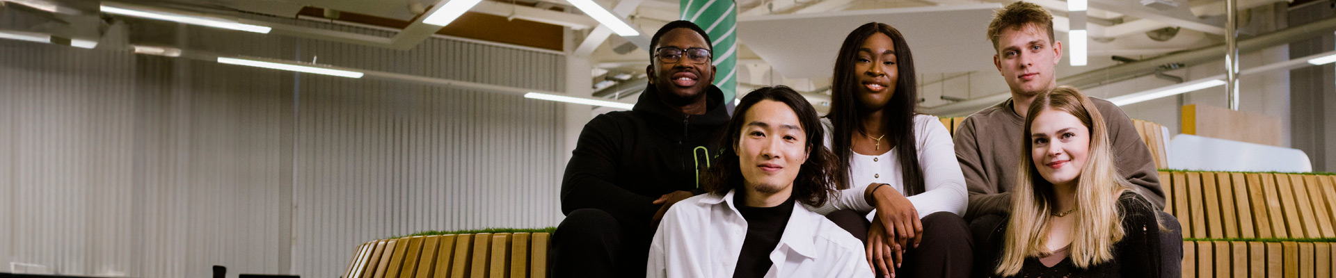 A group of multi-ethnic students sat in the Coventry University Library learning lab.