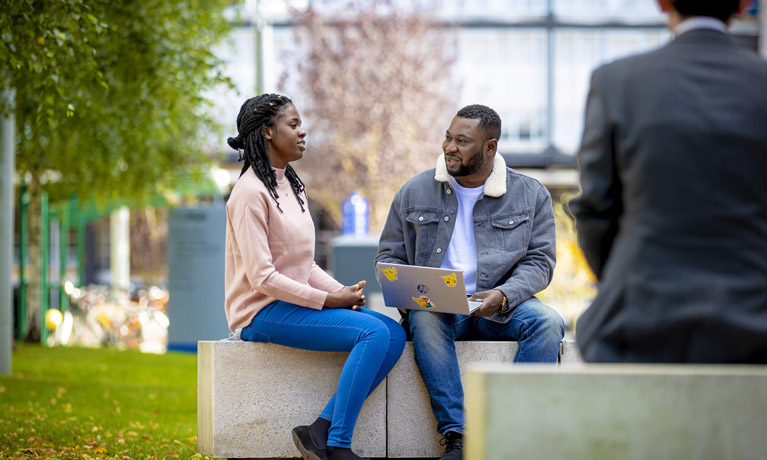 Two international students sat on campus chatting.