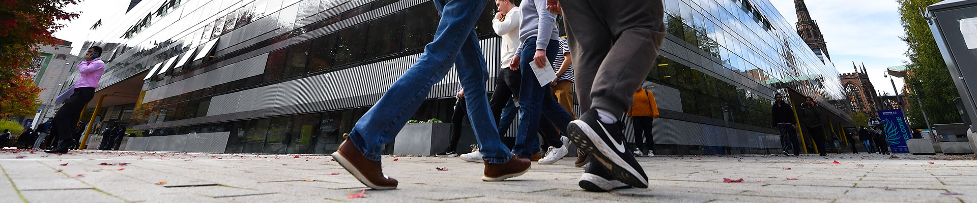 Students walking outside The Hub on a clear day.