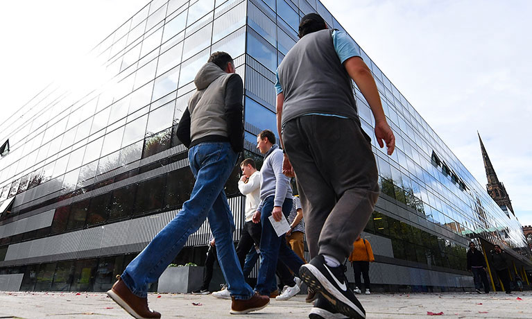 Students walking outside The Hub on a clear day.