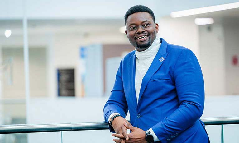 A portrait of Edward wearing a suit and smiling