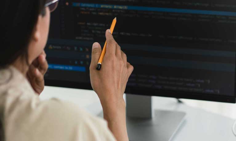 Student holds pencil up to computer screen