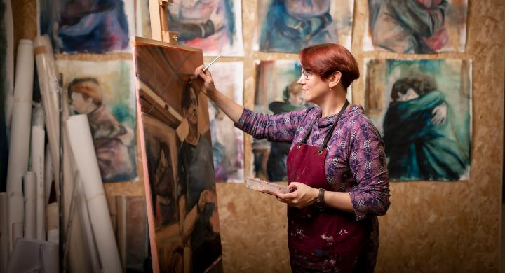 An art student painting on an easel 
