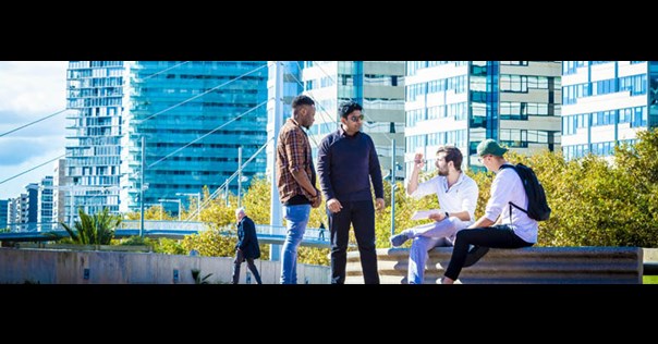 Male students sat outside campus