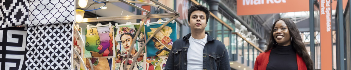 Two students walking through London's Spitalfields Market.