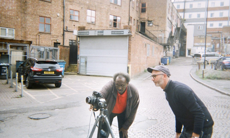 A homeless man and Anthony Luvera looking at a camera on a tripod