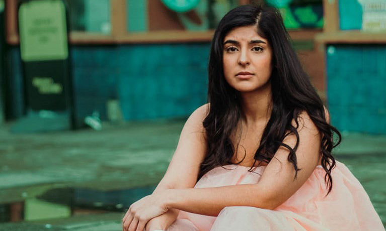 A girl in a pink dress looking at the camera