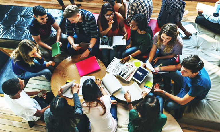 Students studying in a large group in a library.