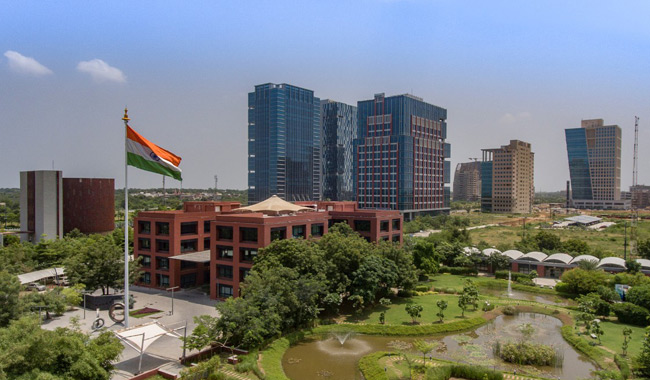 A view of Gift City with a variety of buildings and a lake.