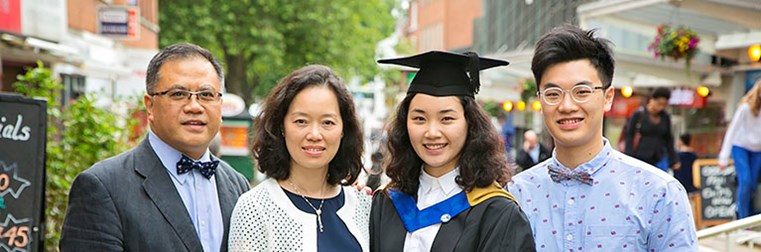 parents and supporters with a student at their graduation