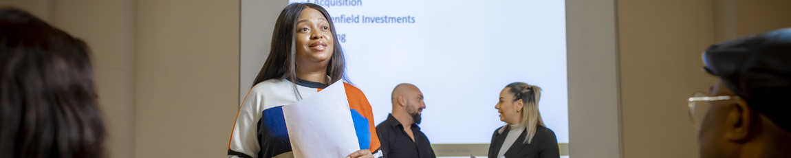 A student giving a presentation to two tutors.