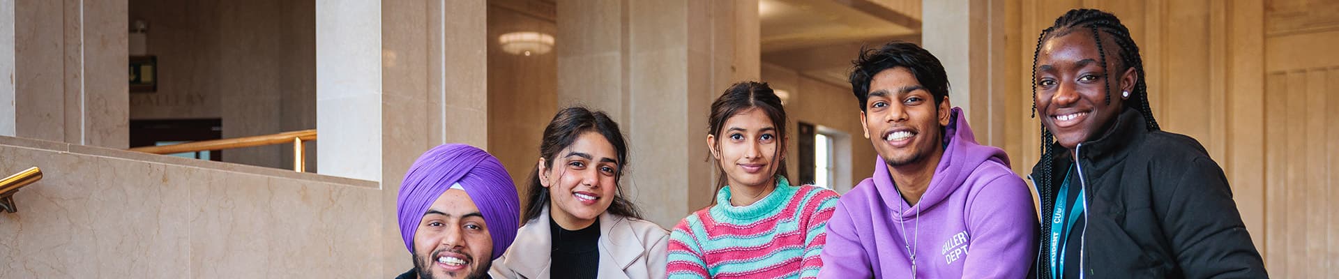 Group of students sitting on some steps smiling